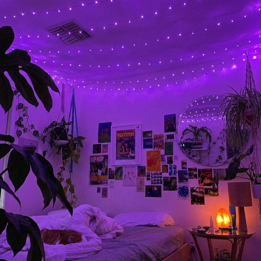 Purple ceiling string lights running across a decorated bedroom