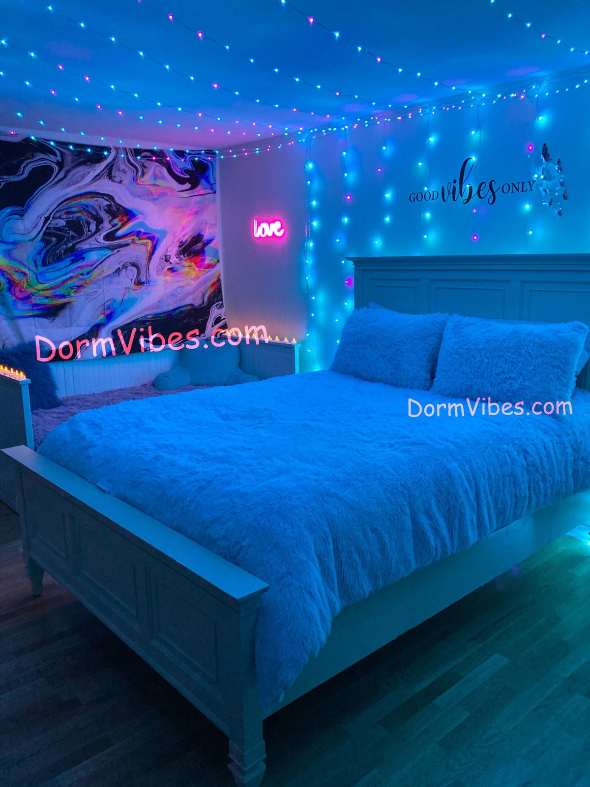 Blue ceiling lights above a bed beside an abstract tapestry