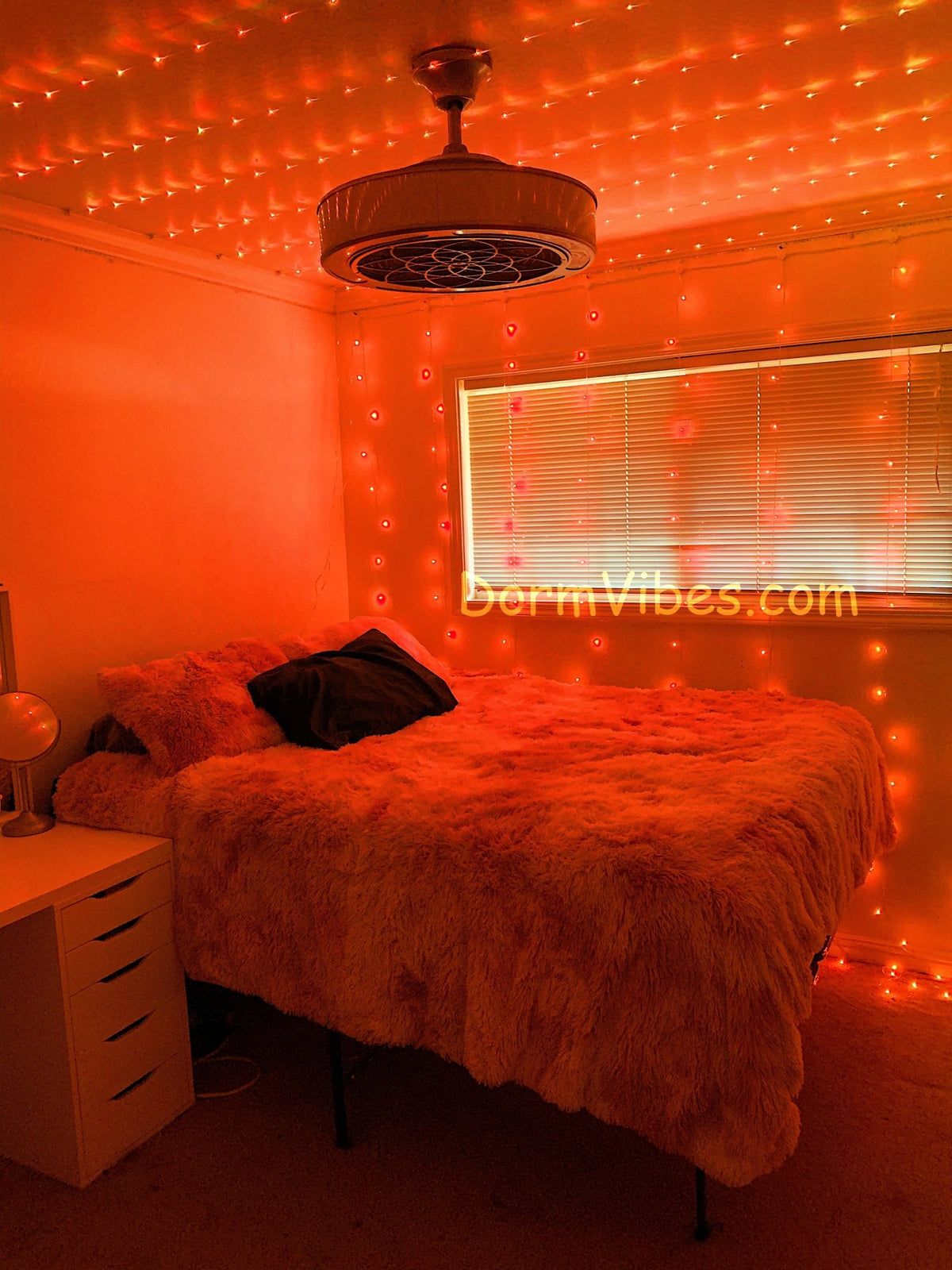 Orange ceiling lights above a bed beside a window