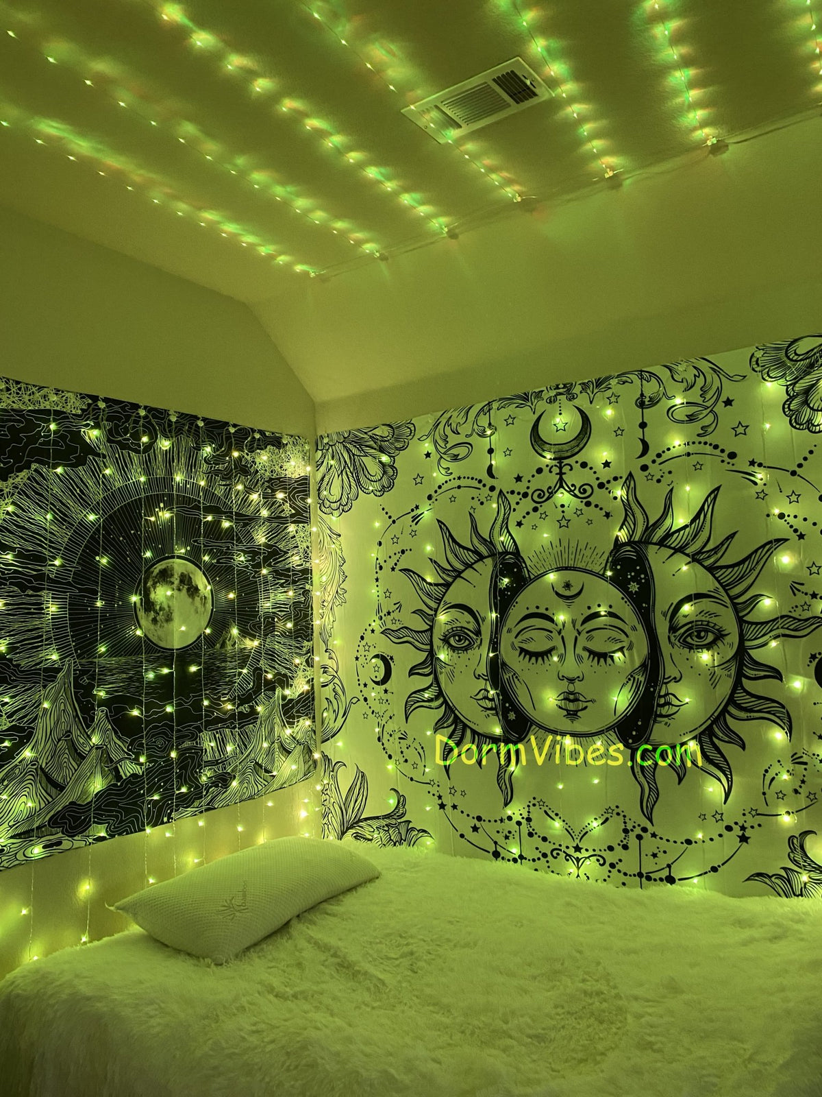 Yellow-green ceiling lights above a bed between celestial tapestries