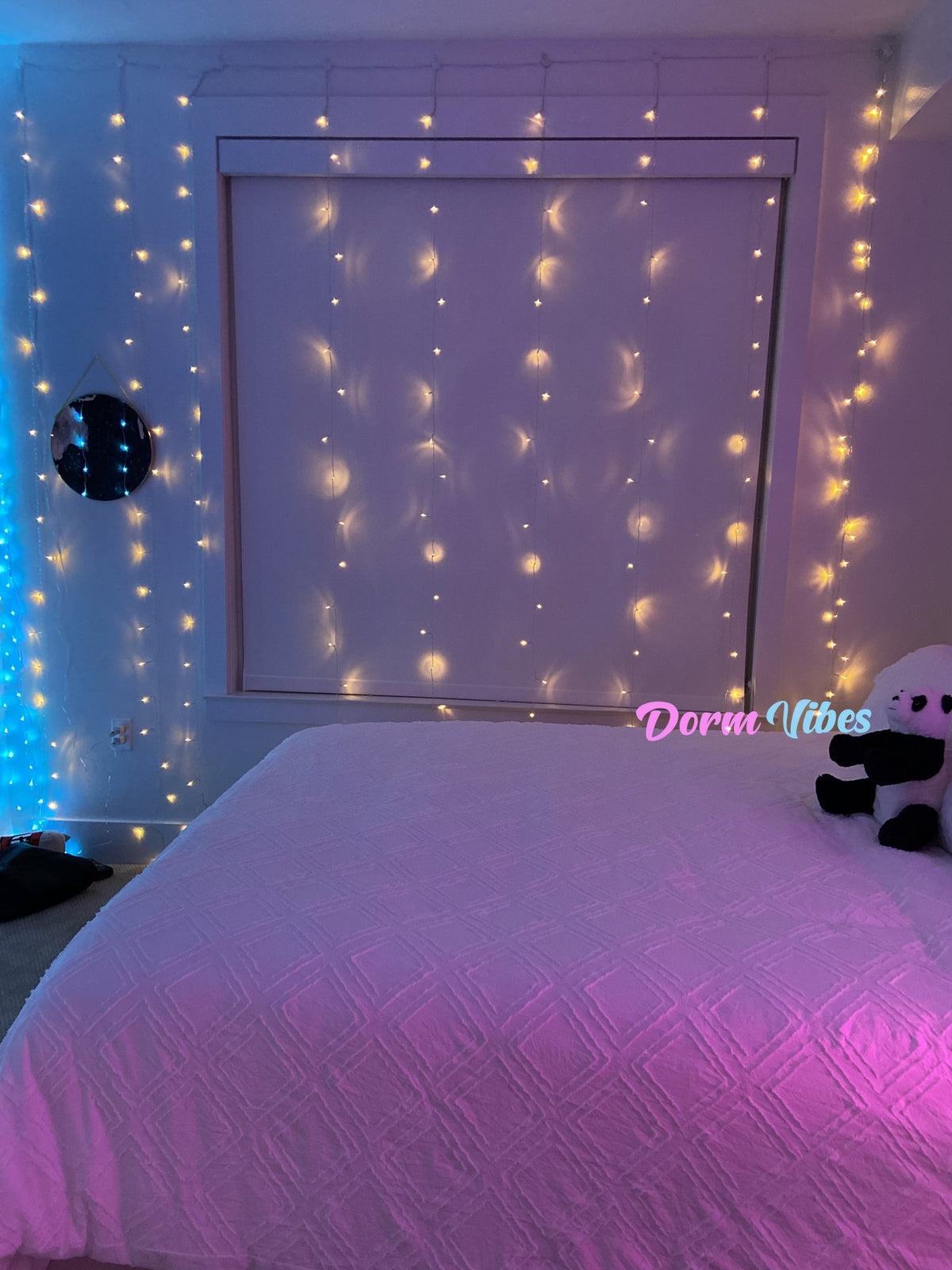 Warm hanging string lights framing a window above a bed