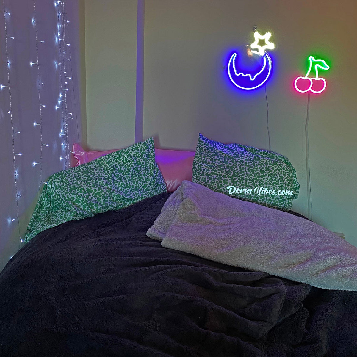 Cherry neon sign above a black bean bag beside moon and star signs