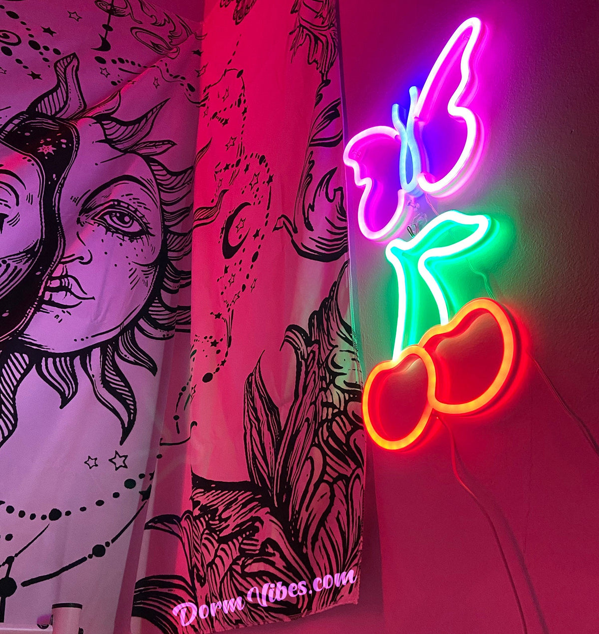 Cherry neon sign beside butterfly lights and a celestial tapestry