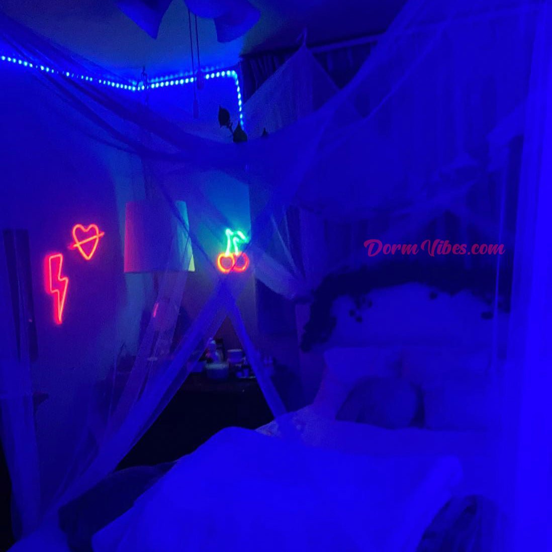 Red heart sign beside a white bedroom canopy and blue lights