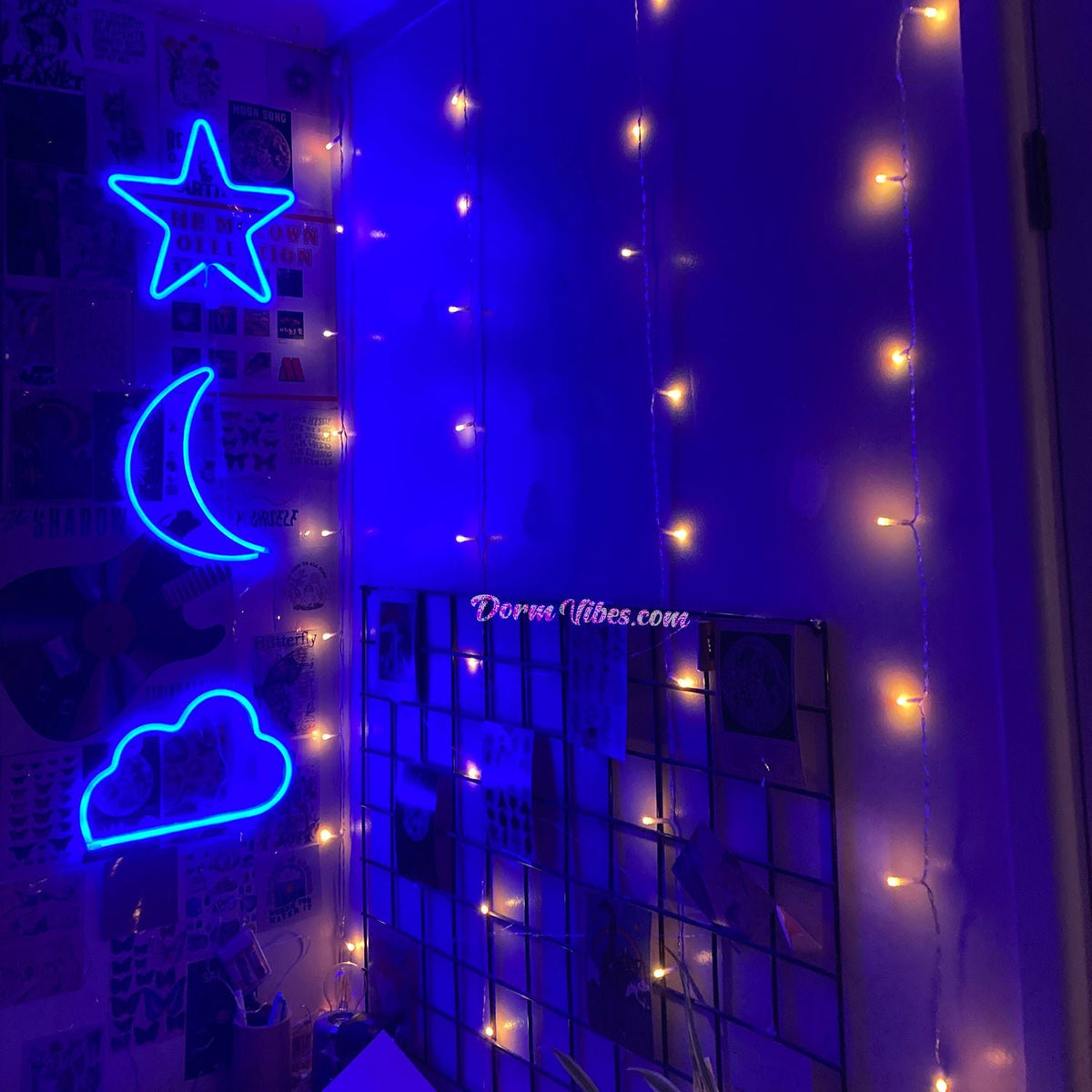 Blue star, moon and cloud signs beside warm hanging lights
