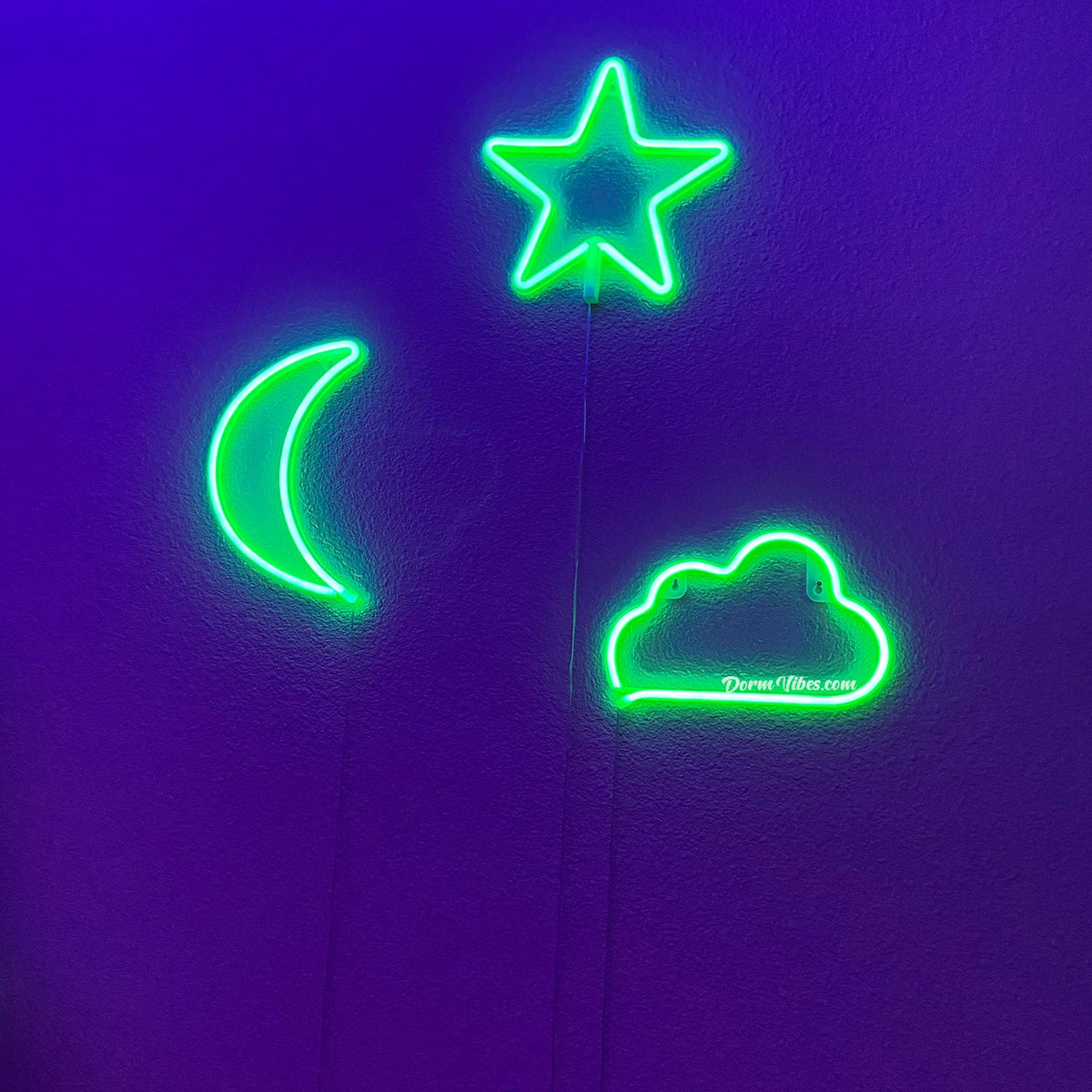 Green night-sky neon sign trio on a dark wall