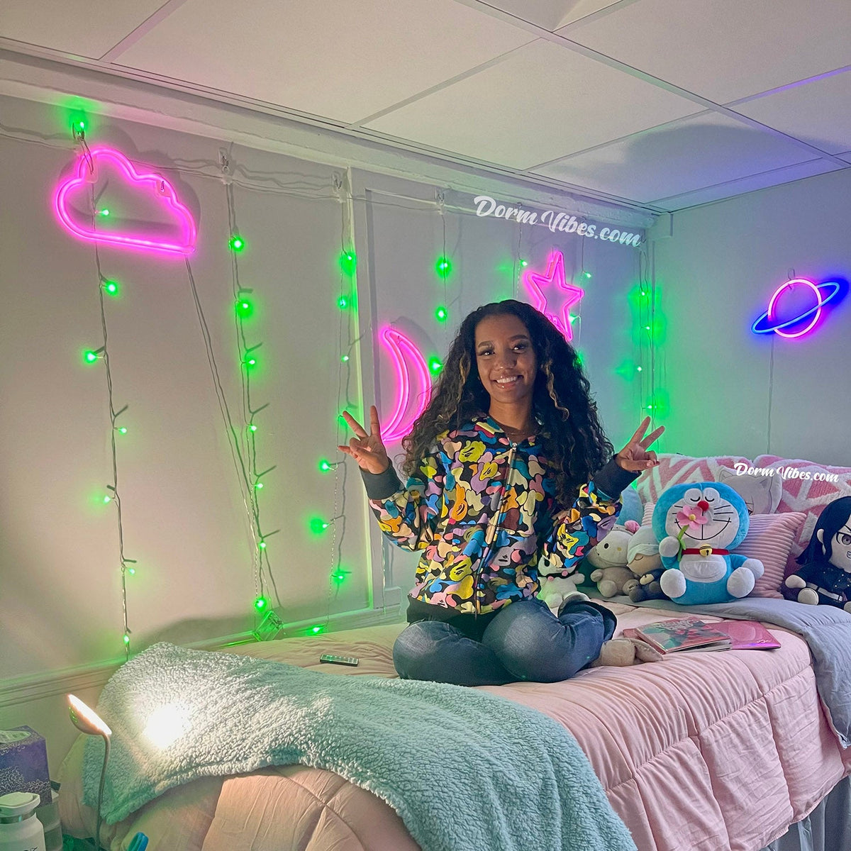 Pink cloud, star and moon wall signs beside green curtain lights