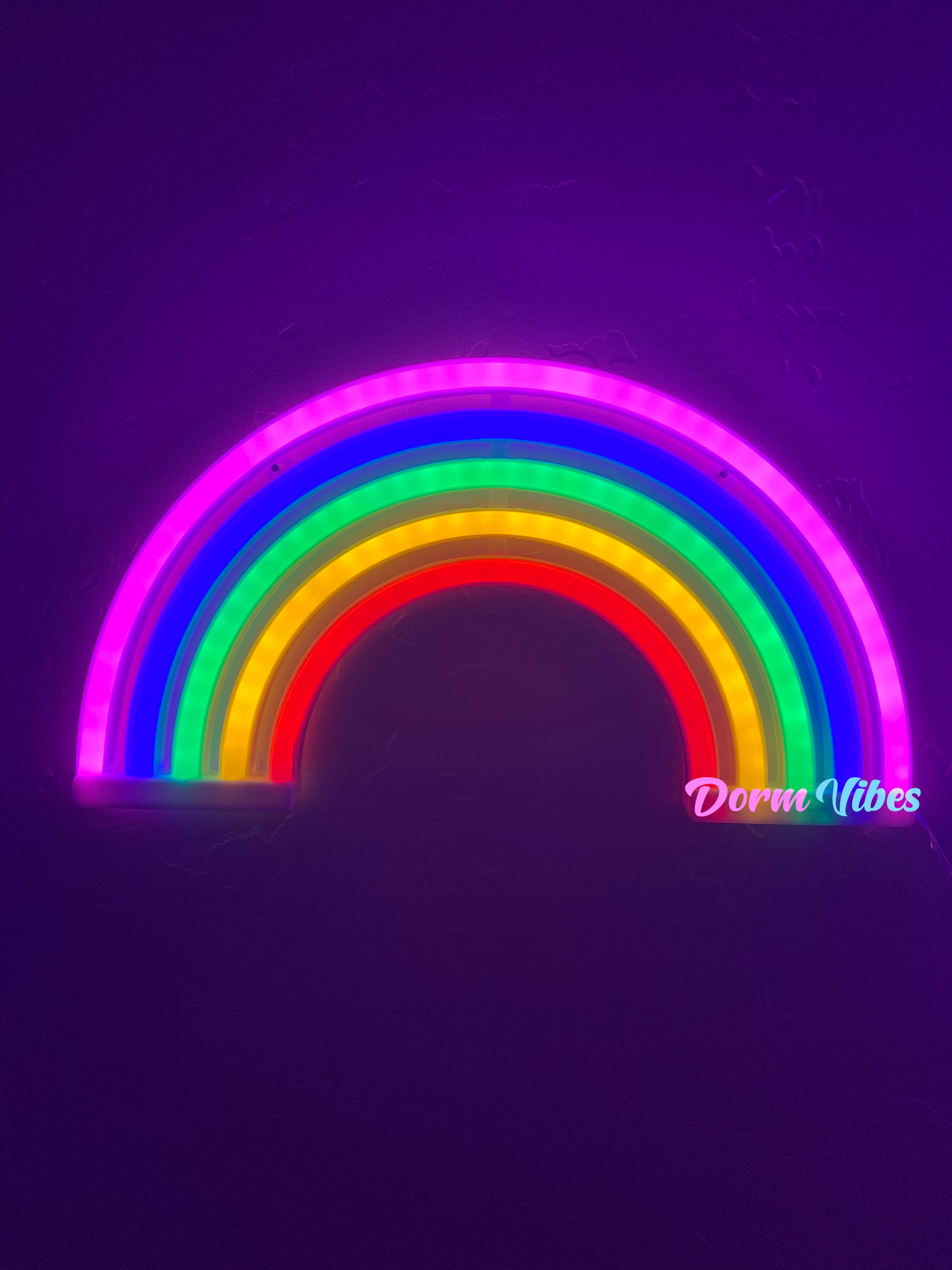 Rainbow-shaped neon sign glowing against a purple background