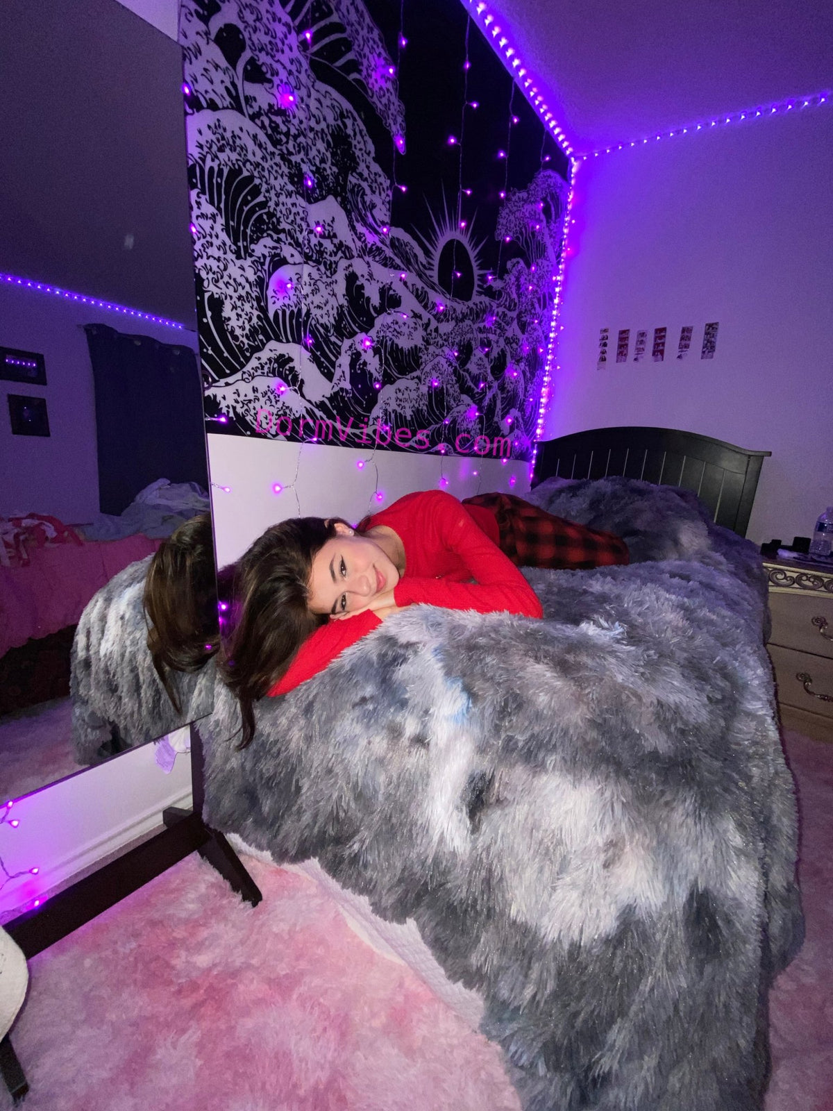 Gray tie-dye rug displayed on a bed in a purple-lit bedroom