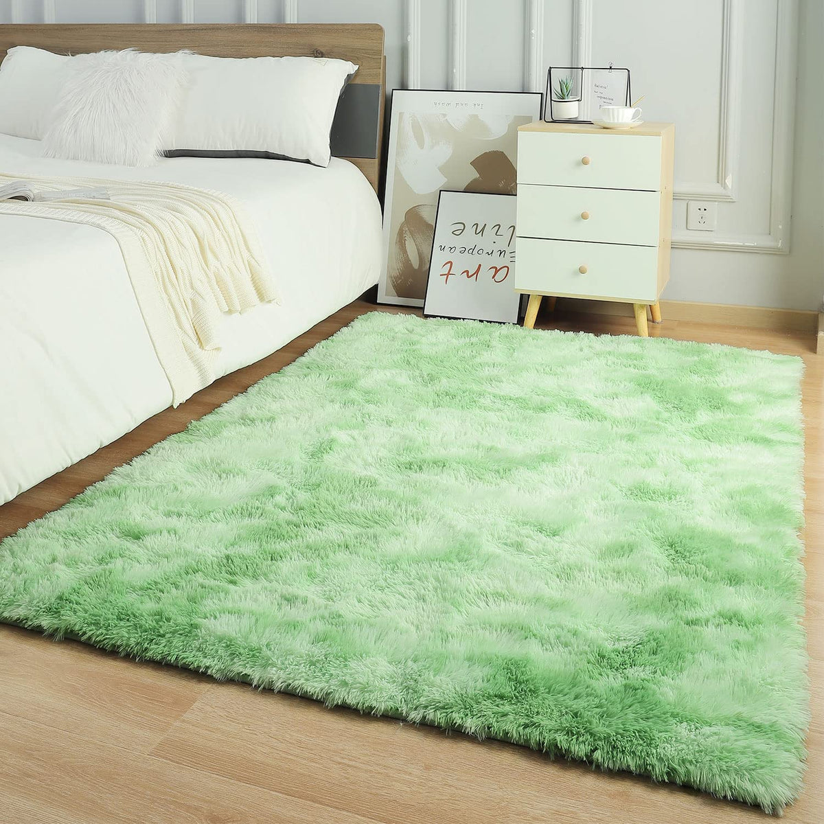 Green and white tie-dye shaggy rug beside a bed